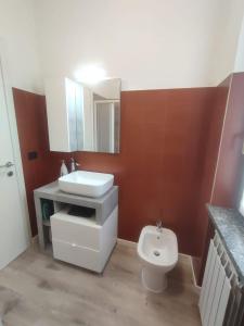 a bathroom with a white sink and a toilet at Villa Verde in Nebbiuno