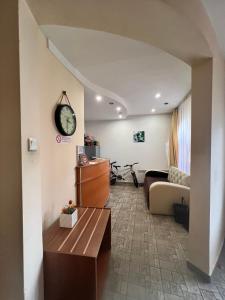 a living room with a couch and a clock on the wall at Family Hotel Square in Ruse