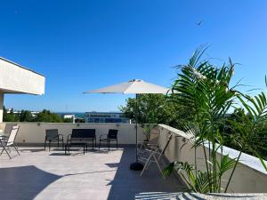 a patio with chairs and an umbrella on a roof at Coralia Luna Park Apartments in Mamaia