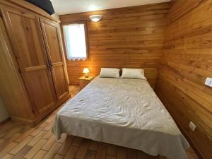 a bedroom with a bed in a wooden room at Les ajoncs in Brocas