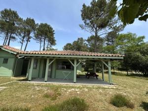 a green house with a picnic table in front of it at Les ajoncs in Brocas