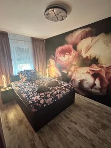 a bedroom with a bed with flowers on the wall at U Lilki in Bolesławiec
