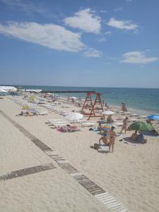 a group of people on a beach with umbrellas at Домик у моря in Odesa +7 photos