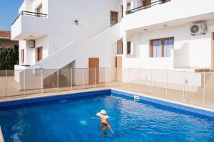 基索内加Bright sea view suite with sunset & pool Paphos的建筑物游泳池里的人 更多5张照片