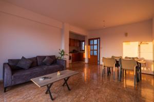 基索内加Bright sea view suite with sunset & pool Paphos的带沙发、桌子和椅子的客厅