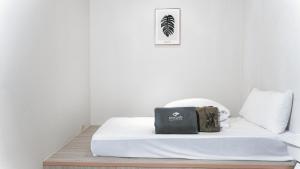 a bed in a white room with a bag on it at 婧仕女微旅 in Hou-lung-tzu +39 photos