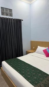 a bedroom with a bed with a black curtain at Remedy in Lagas in Ubud