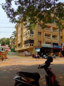 a motorcycle parked on the street in front of a building at Alice's Cozy Abode in Udupi