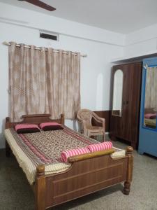 a bedroom with a wooden bed and a window at Alice's Cozy Abode in Udupi