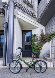 a green bike parked in front of a building at お宿Ｇａｎ福田町-Luxury Stay-駐車場無料 in Takamatsu