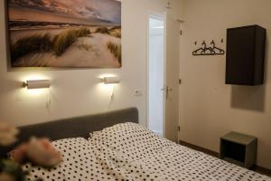 a bedroom with a bed and a painting on the wall at Fijn chalet vlakbij Zeeuwse kust, op familiepark VP047 in Heinkensand +51 photos