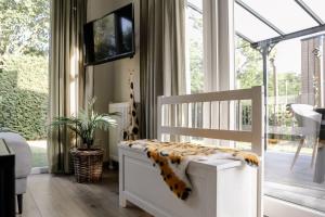 a baby crib with a cheetah blanket on it at Fijn chalet vlakbij Zeeuwse kust, op familiepark VP047 in Heinkensand