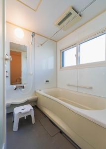 a bathroom with a tub and a window and a stool at お宿Ｇａｎ福田町-Luxury Stay-駐車場無料 in Takamatsu +41 photos