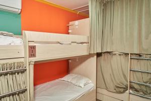 two bunk beds in a room with an orange wall at day to day in Almaty
