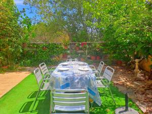 Una mesa con sillas blancas y un mantel azul y blanco. en Villa Petunia, en GRO
