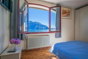 a bedroom with a window with a view of the water at La Fabbrichetta Leonardolake in Ghiffa