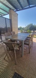 - une table de pique-nique et des chaises sur la terrasse dans l'établissement Turtle Bay Village garden 2-bedroom sea apartment, à Kyrenia