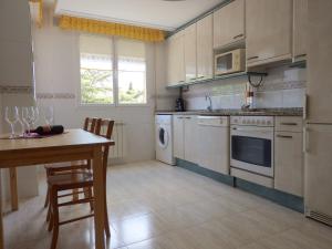 a kitchen with white cabinets and a table and a counter at El Parque Navajas in Fuenmayor