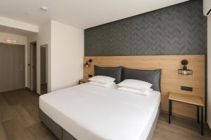 a large white bed with two pillows in a bedroom at Athens coast hotel in Athens