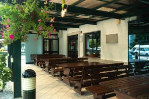 a row of wooden tables and benches in a restaurant at Hotel Tabor in Sežana
