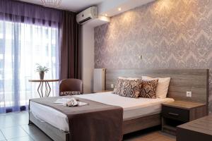 a hotel room with a bed and a chair at Limani Comfort Rooms in Thessaloniki