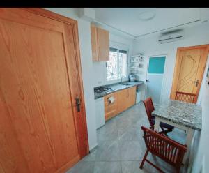 eine Küche mit einem Tisch und einer Holztür in der Unterkunft Saidia Residence in Saidia  + 13 Fotos