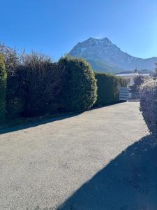 a driveway with a house and a mountain in the background at Villa unique, 50 mètres du jardin au lac in Savines +46 photos