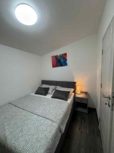 Un dormitorio con una cama y una mesa con una lámpara. en Apartments Leona, en Rogoznica