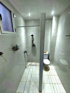 ein weißes Bad mit einem WC und einem Fenster in der Unterkunft Saidia Residence in Saidia 