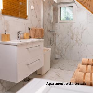 a white bathroom with a shower and a sink at Apartmaji Taler in Bohinj
