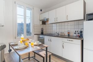 a kitchen with white cabinets and a table with food on it at Chill & Work - Welc'Home in Limoges