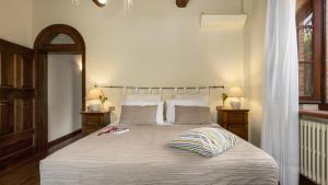 トッリータ・ディ・シエーナにあるVILLA LA MONARCA 16, Emma Villasの大きなベッドと2つのナイトスタンドを備えた寝室
