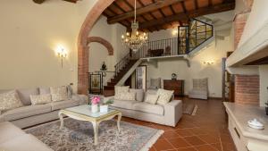トッリータ・ディ・シエーナにあるVILLA LA MONARCA 16, Emma Villasのソファとテーブルのあるリビングルーム