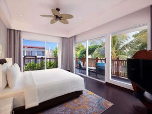 a bedroom with a bed and a balcony at Grand Mercure Bali Seminyak in Seminyak