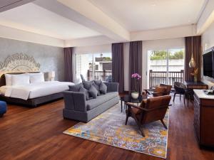 a bedroom with a bed and a living room at Grand Mercure Bali Seminyak in Seminyak