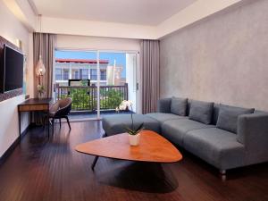 a living room with a couch and a table at Grand Mercure Bali Seminyak in Seminyak