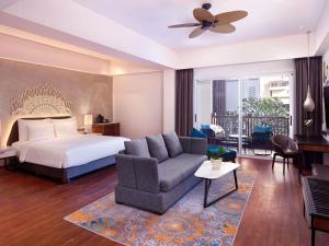 a hotel room with a bed and a couch at Grand Mercure Bali Seminyak in Seminyak