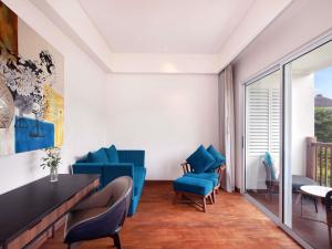 a living room with blue chairs and a table at Grand Mercure Bali Seminyak in Seminyak
