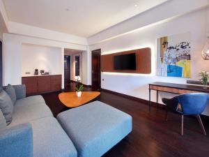 a living room with a couch and a table at Grand Mercure Bali Seminyak in Seminyak