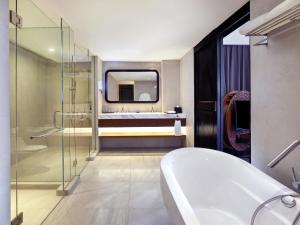 a bathroom with a tub and a sink at Grand Mercure Bali Seminyak in Seminyak