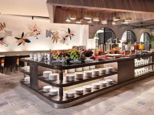 a buffet line with food on display in a restaurant at Grand Mercure Bali Seminyak in Seminyak