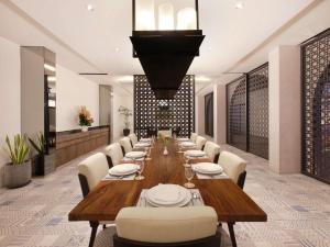 a dining room with a long table and chairs at Grand Mercure Bali Seminyak in Seminyak