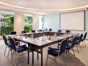 a conference room with a large table and chairs at Grand Mercure Bali Seminyak in Seminyak