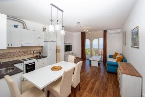a kitchen and living room with a table and chairs at Apartments Natasa in Sveti Stefan