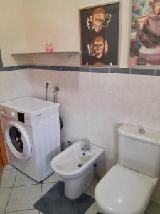 a bathroom with a toilet and a washing machine at Anisa Home 2 in Senna Comasco