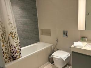 a bathroom with a tub and a toilet and a sink at Best Emaar Beachfront view one bedroom in Dubai +7 photos