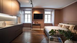 a bedroom with a bed and a kitchen with a sink at Dimora Vianello Rooms in Trieste