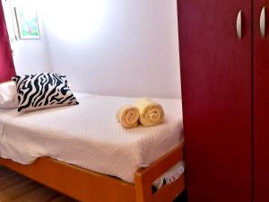 a small bedroom with a bed with towels on it at Apartment Zagor Split in Split