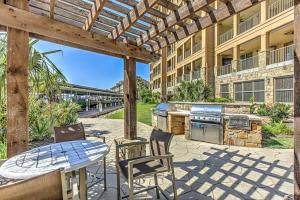 a patio with an outdoor kitchen with a table and chairs at Waterfront Condo for 4 with Resort Pool & Lake View in Horseshoe Bay