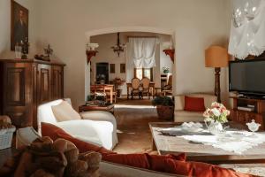 a living room with a couch and a tv at Villa Gnecchi Lake Como in Garlate